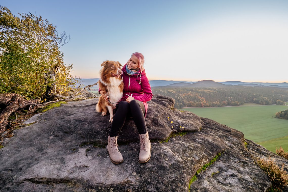 Australian Shepherd und Frauchen auf Berggipfel zur Dämmerung