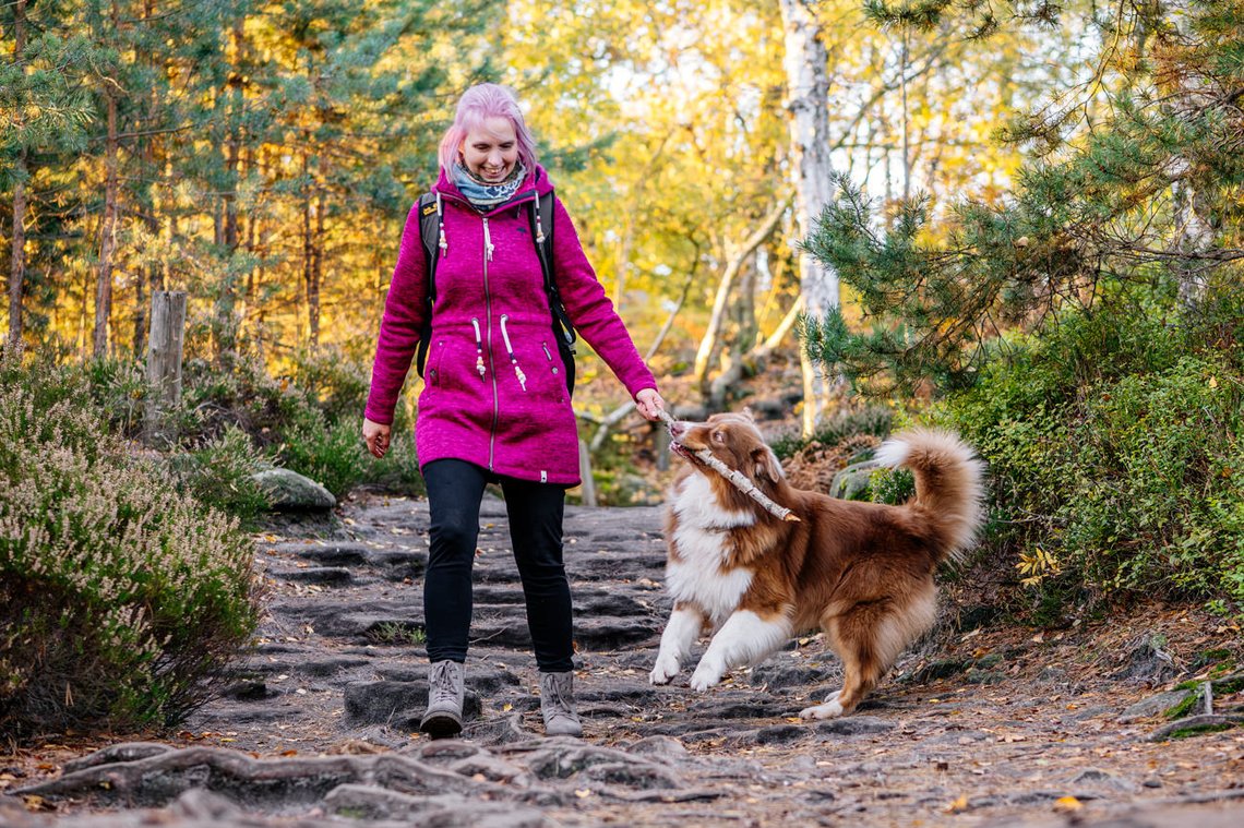 Australian Shepherd und Besitzerin spielen
