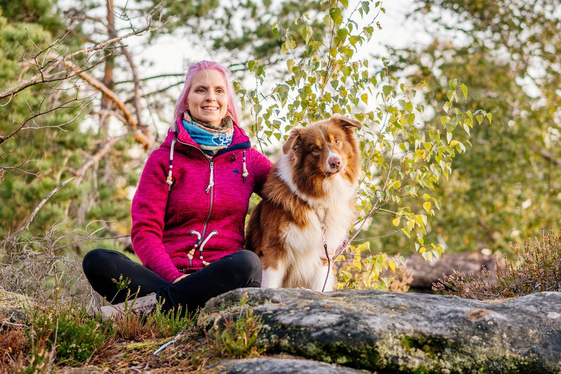 Australian Shepherd und Frauchen bei Wanderpause