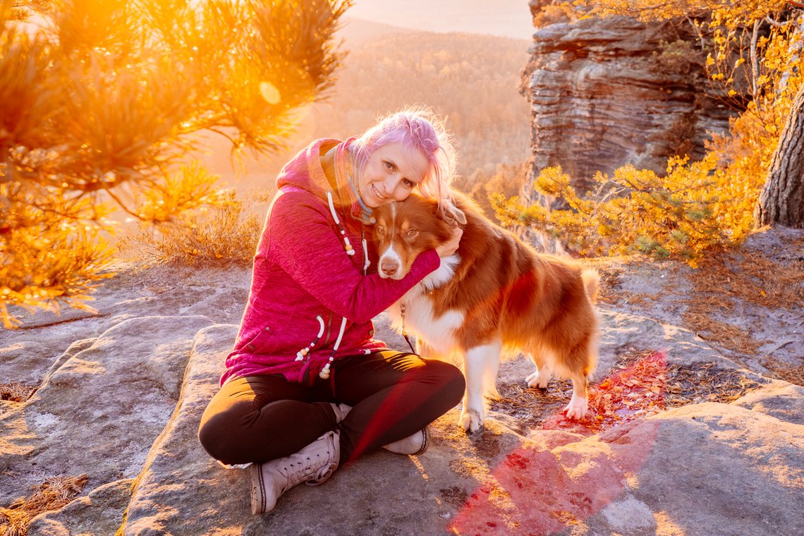 Hund und Mensch kuscheln in der Sächsischen Schweiz bei Sonnenaufgang