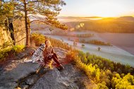 Hündin und Frauchen bei Sonnenaufgang in den Bergen Sächsische Schweiz