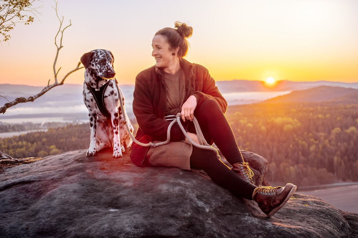 Dalmatiner und Frauchen auf dem Gipfel bei Sonnenaufgang im Elbsandsteingebirge