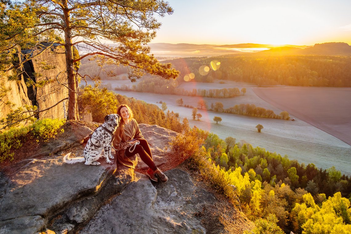 Hündin und Frauchen bei Sonnenaufgang in den Bergen Sächsische Schweiz