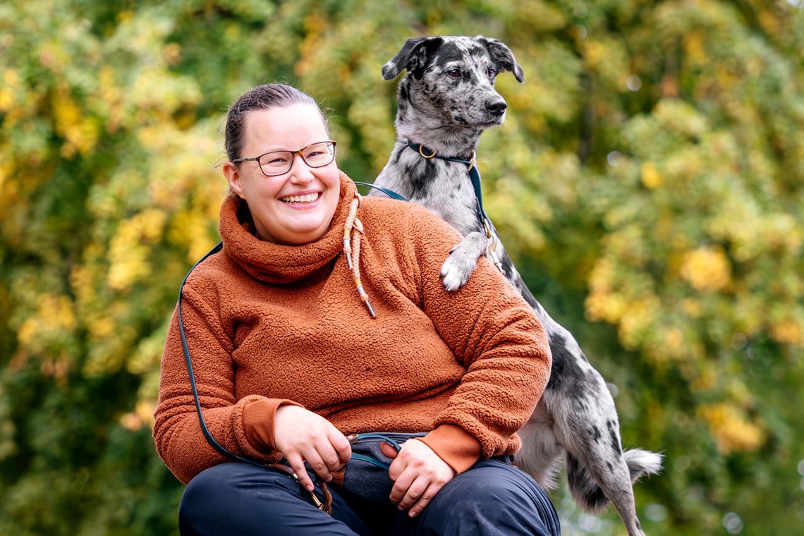 Mischling schaut über Schulter von Frauchen