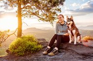Hund und Halter im Sonnenaufgang in den Bergen