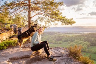 Huskymix steht auf den Schultern vom Frauchen