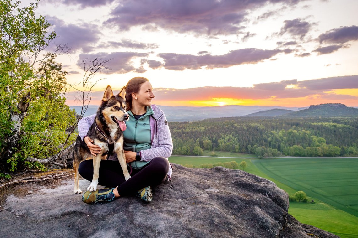 Hund und FRauchen blicken in die Ferne
