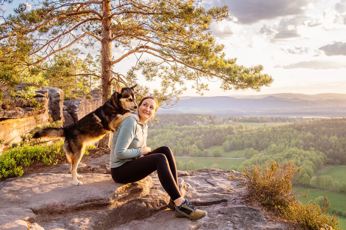 Huskymix steht auf den Schultern vom Frauchen
