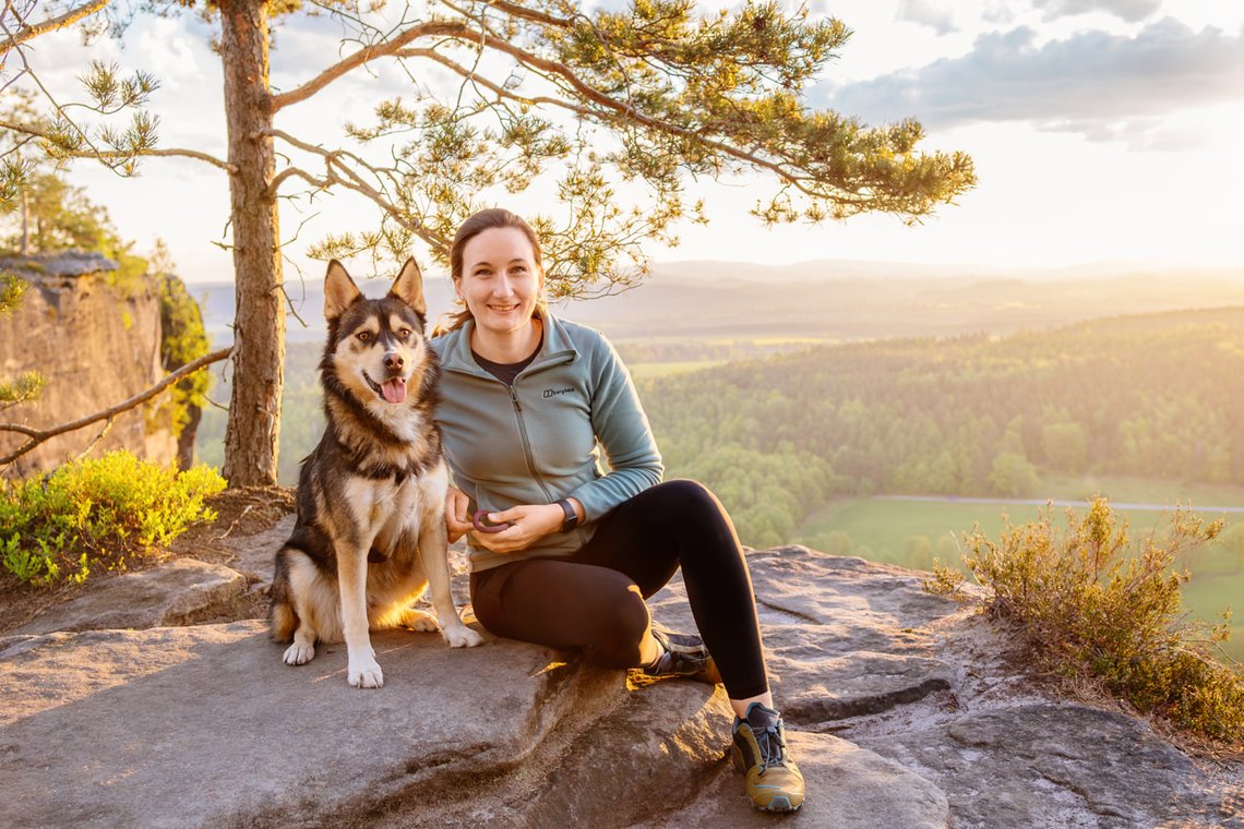 Hund und Halter im Sonnenaufgang in den Bergen