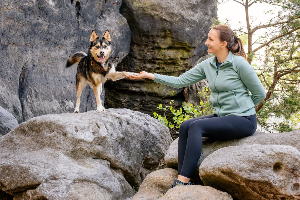 Huskymix und Frauchen auf Felsen Hund gibt Pfote