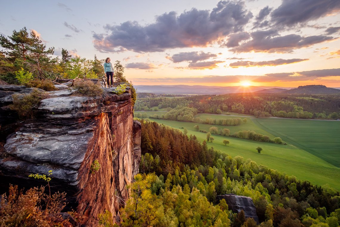 Mischlingshündin und Frauchen stehen am Abgrund eines Gipfels im Elbsandsteingebirge
