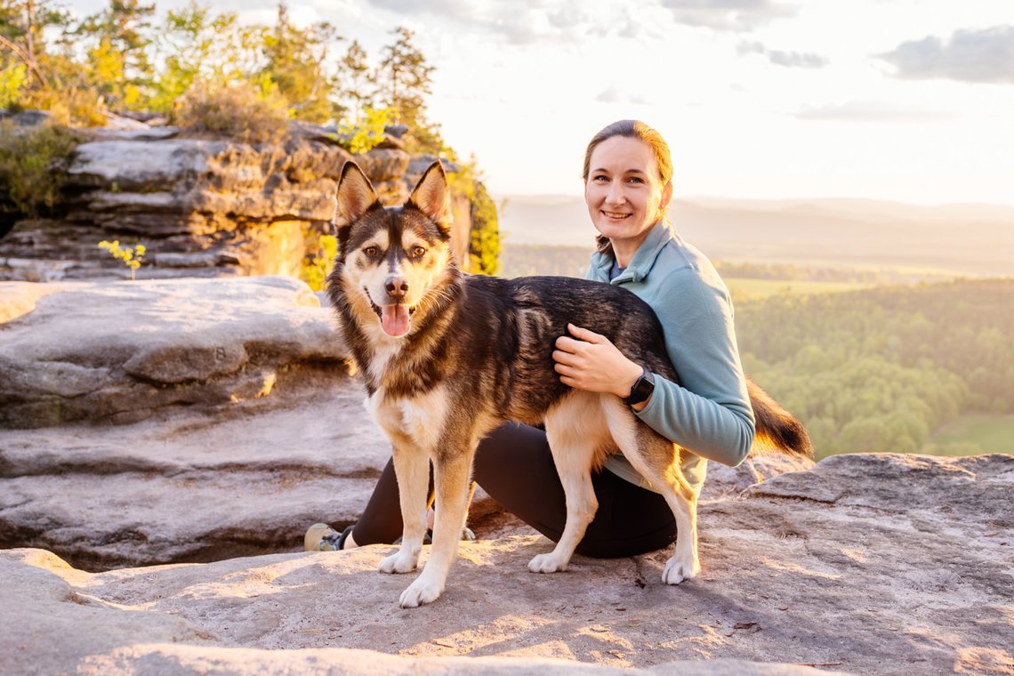 Hund und Halter im Sonnenaufgang in den Bergen
