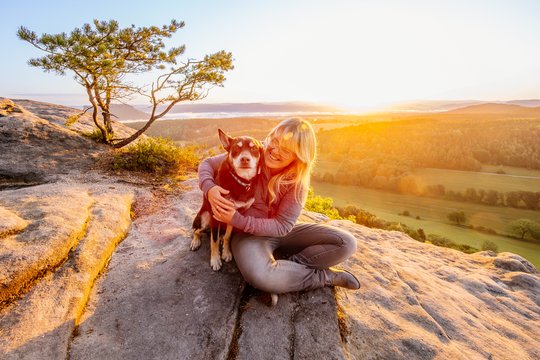 Working Kelpie und Hundehalterin verbringen Zeit beim Sonnenaufgang in den Bergen der Sächsischen Schweiz