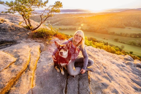Working Kelpie und Hundehalterin verbringen Zeit beim Sonnenaufgang in den Bergen der Sächsischen Schweiz