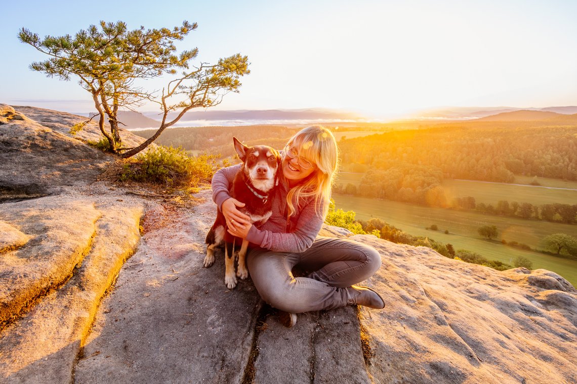 Working Kelpie und Hundehalterin verbringen Zeit beim Sonnenaufgang in den Bergen der Sächsischen Schweiz